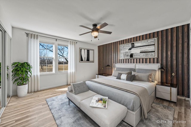 bedroom with a closet, wood finished floors, and a ceiling fan