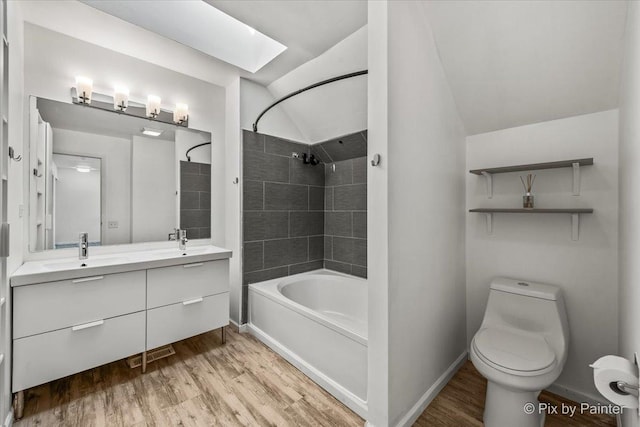 bathroom with wood finished floors, bathtub / shower combination, and a sink