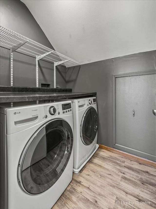 washroom with light wood-type flooring, independent washer and dryer, and laundry area