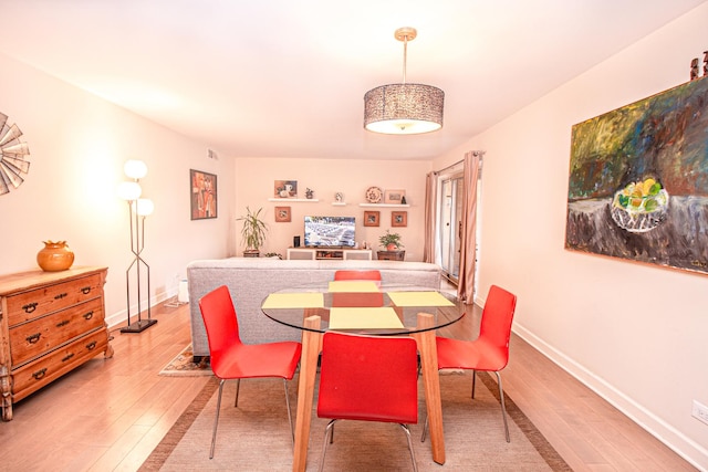 dining area with light wood-style flooring and baseboards