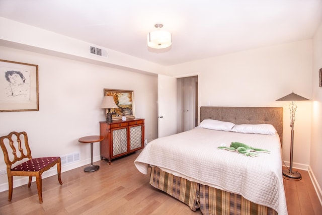 bedroom featuring baseboards, visible vents, and light wood-type flooring