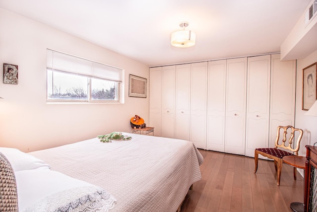 bedroom with light wood-style floors and visible vents