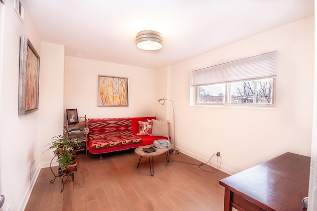 sitting room with hardwood / wood-style floors, baseboards, and visible vents