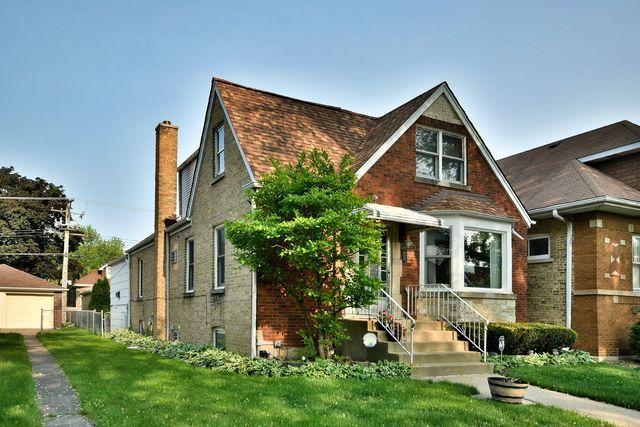 english style home with a front yard and a chimney