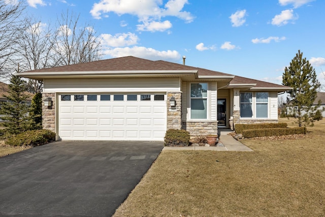 prairie-style home with a front yard, a garage, stone siding, and driveway