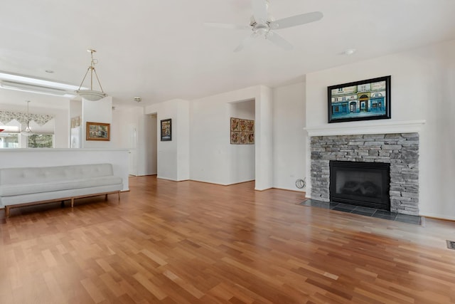 unfurnished living room with a fireplace, ceiling fan, and wood finished floors