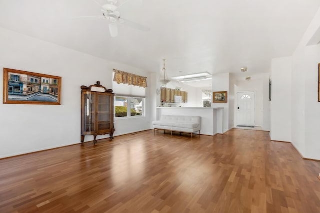 unfurnished living room with baseboards, a ceiling fan, and wood finished floors