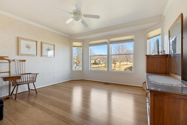 sitting room with light wood-type flooring, crown molding, and baseboards