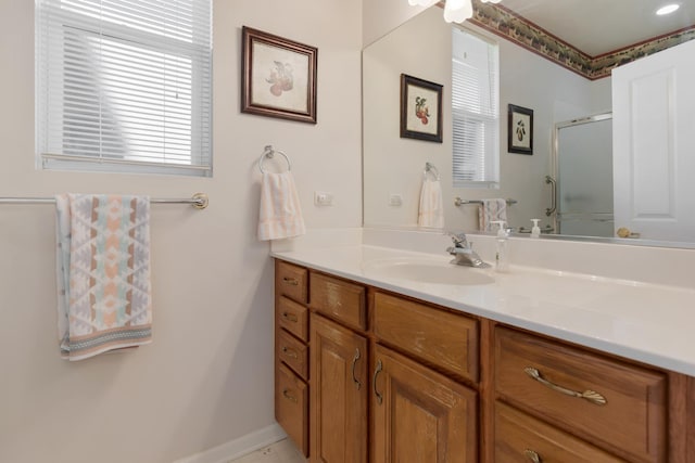 bathroom featuring a wealth of natural light, an enclosed shower, vanity, and baseboards