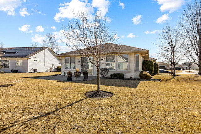 rear view of property featuring central AC unit and a lawn