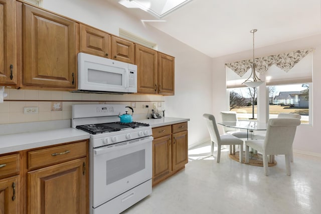 kitchen with tasteful backsplash, brown cabinets, white appliances, and light countertops