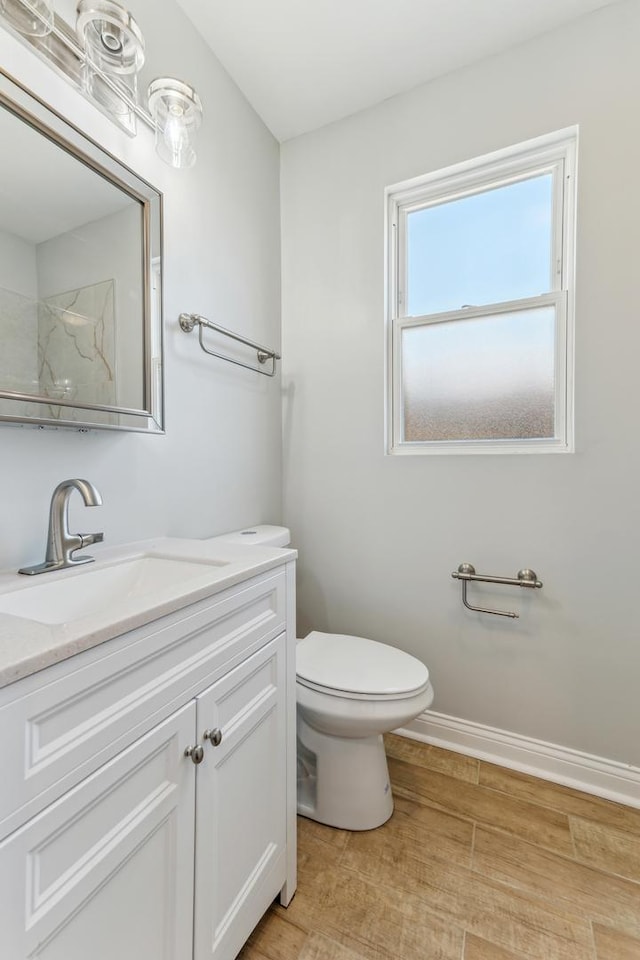 full bathroom featuring baseboards, toilet, wood finished floors, vanity, and a shower