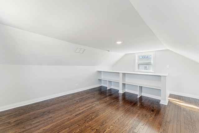 additional living space with lofted ceiling, baseboards, and dark wood-style flooring