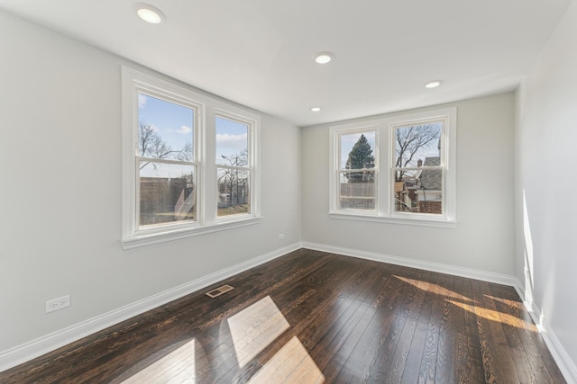 unfurnished room with recessed lighting, visible vents, baseboards, and dark wood-style floors