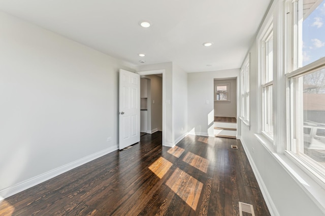 spare room with dark wood finished floors, recessed lighting, baseboards, and visible vents