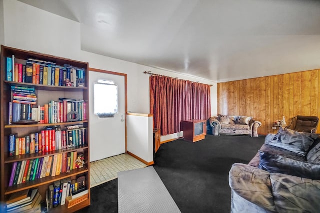 carpeted living area with wooden walls