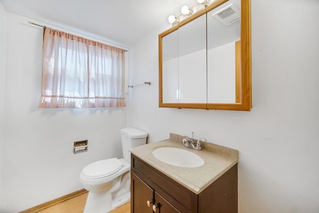 half bath featuring visible vents, toilet, and vanity