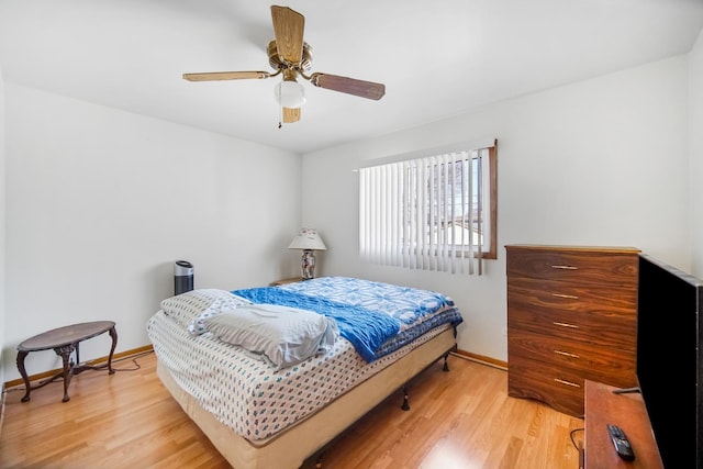 bedroom featuring a ceiling fan, baseboards, and wood finished floors