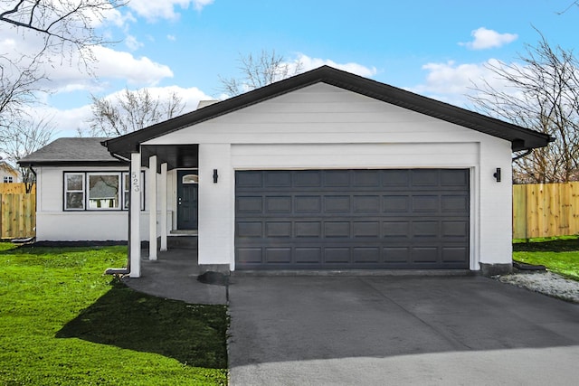 ranch-style home featuring a front yard, fence, and a garage