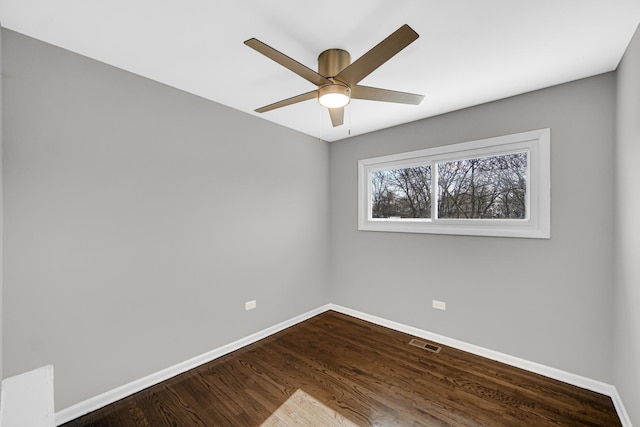 unfurnished room featuring baseboards, visible vents, and dark wood-style flooring