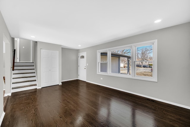 unfurnished living room featuring stairway, recessed lighting, wood finished floors, and baseboards