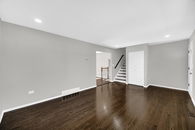 unfurnished living room with visible vents, wood finished floors, recessed lighting, stairway, and baseboards