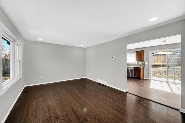 unfurnished living room with dark wood-type flooring, recessed lighting, visible vents, and baseboards