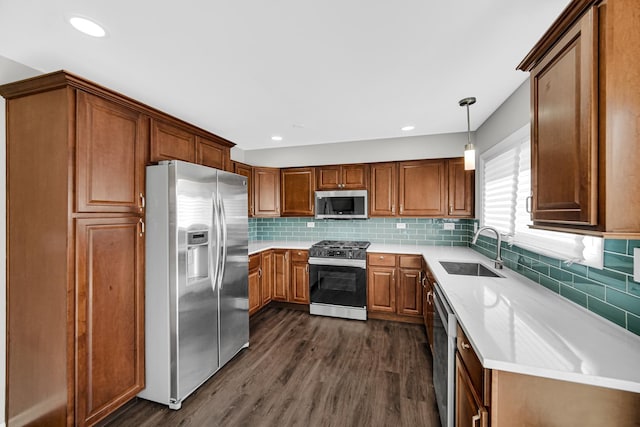 kitchen with dark wood-style flooring, stainless steel appliances, light countertops, and a sink