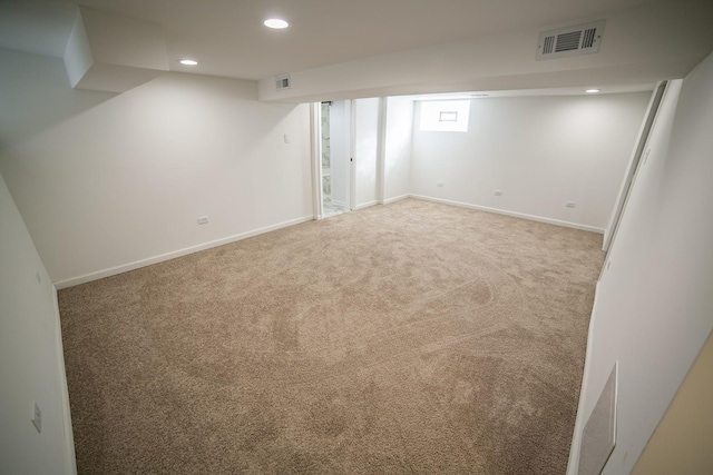 below grade area featuring carpet flooring, recessed lighting, visible vents, and baseboards