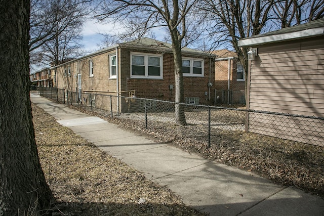 view of home's exterior with a fenced front yard and brick siding