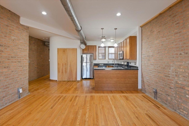 1637 W Pratt Blvd Unit 2W, Chicago, IL 60626 - kitchen with appliances with stainless steel finishes, brick wall, dark countertops, light wood-style flooring, and brown cabinets