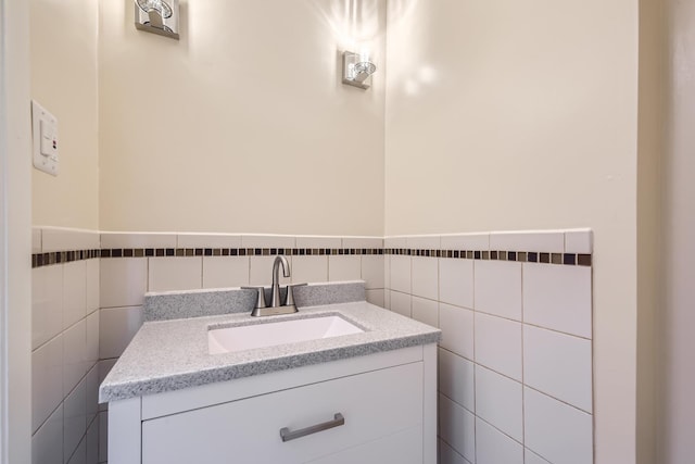 bathroom featuring wainscoting, vanity, and tile walls