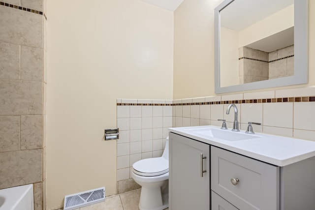 bathroom featuring tile patterned flooring, visible vents, toilet, vanity, and tile walls