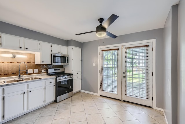 kitchen with a sink, stainless steel appliances, tasteful backsplash, and white cabinets