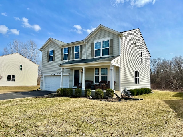 traditional-style home with a porch, an attached garage, driveway, and a front yard