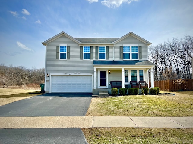 traditional home with driveway, a porch, fence, a front yard, and a garage