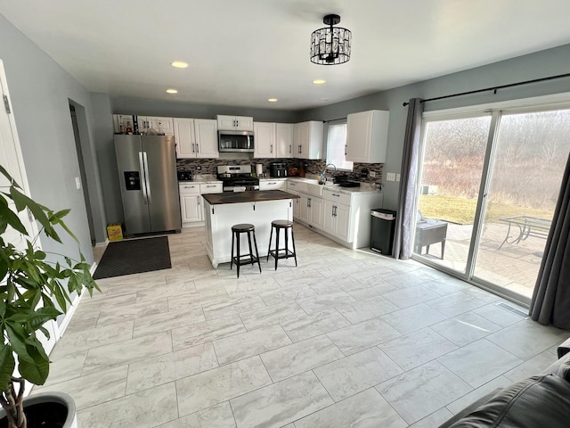 kitchen featuring white cabinetry, a sink, backsplash, and stainless steel appliances