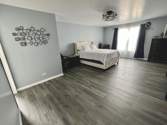 bedroom featuring baseboards and dark wood-style floors