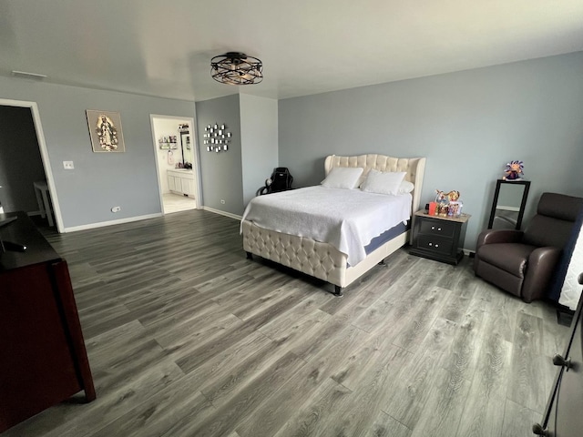 bedroom with visible vents, wood finished floors, baseboards, and connected bathroom