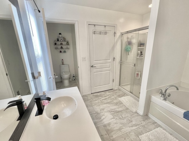 bathroom featuring vanity, a stall shower, a garden tub, toilet, and marble finish floor