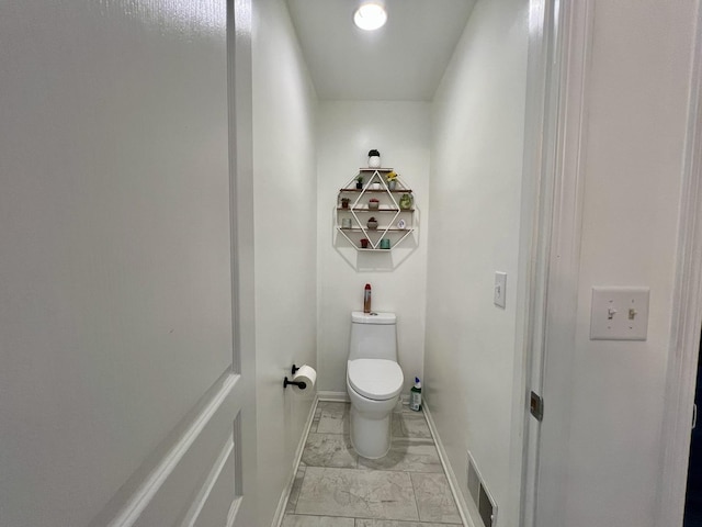 bathroom featuring visible vents, baseboards, toilet, and marble finish floor