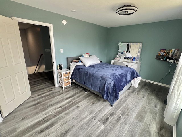 bedroom featuring baseboards and light wood finished floors