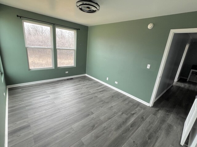 spare room with visible vents, wood finished floors, and baseboards