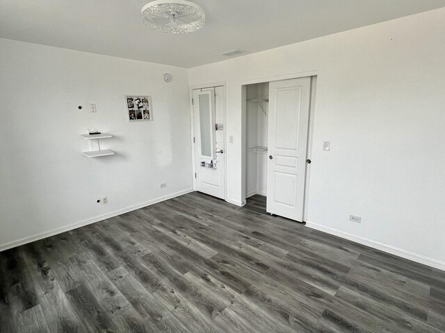 unfurnished bedroom featuring dark wood-type flooring and baseboards