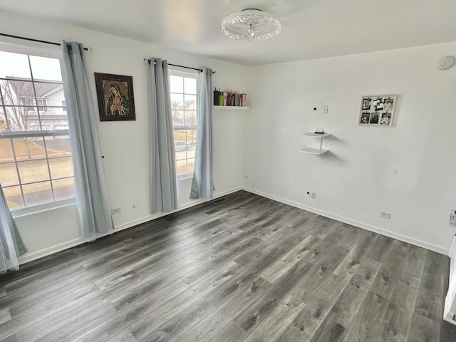 empty room featuring baseboards and wood finished floors