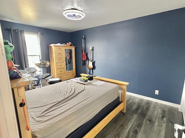 bedroom featuring wood finished floors and baseboards