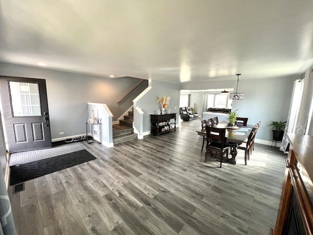 dining space with visible vents, baseboards, dark wood-type flooring, and stairs