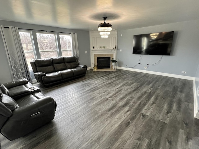 living area with a fireplace, baseboards, and wood finished floors