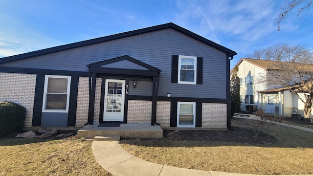 view of front of house featuring a front lawn and brick siding