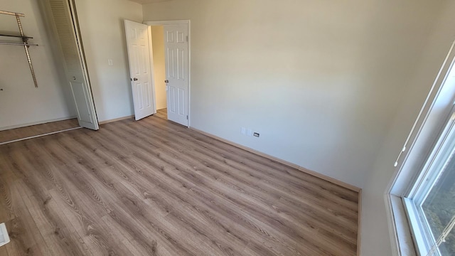 unfurnished bedroom with light wood-style flooring and a closet